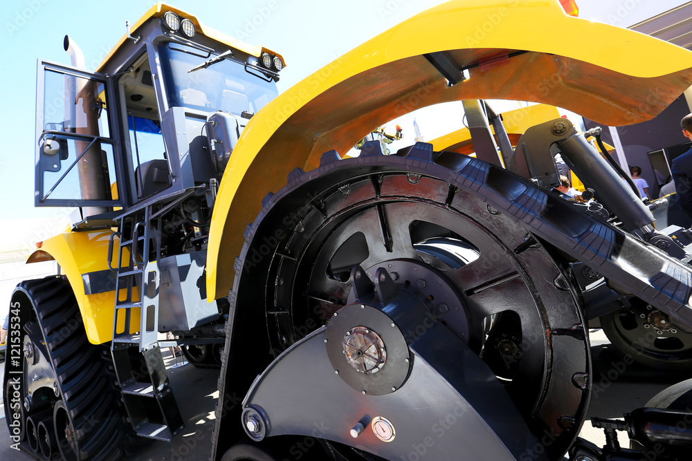 Fototapeta premium Big black wheel yellow construction truck with steps