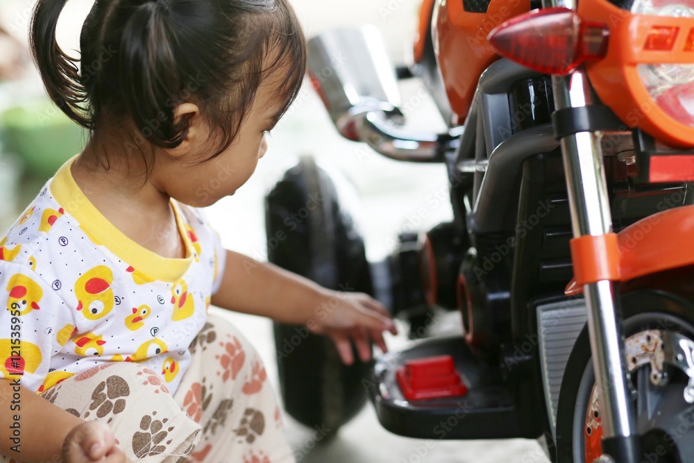 girl playing motorcycle toy girl playing motorcycle toy