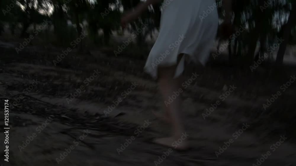 Crime. Frightened girl,  young woman crawls. runs away from the killer, murderer. Rapist, bad man which it pursues and eventually kills. Dark forest at night.