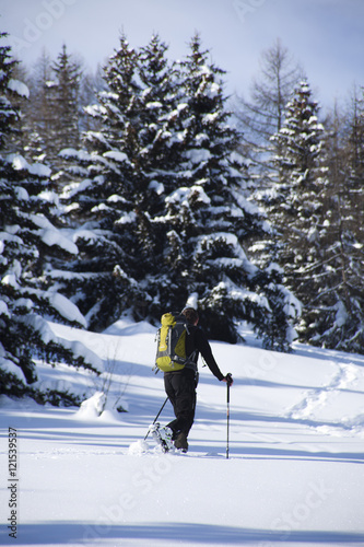 homme qui marche dans la forêt dans la neige avec un sac à dos