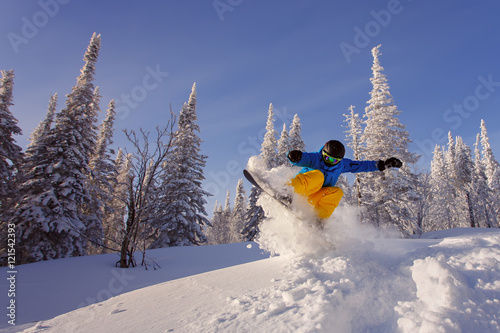 Snowboarder jumping photo