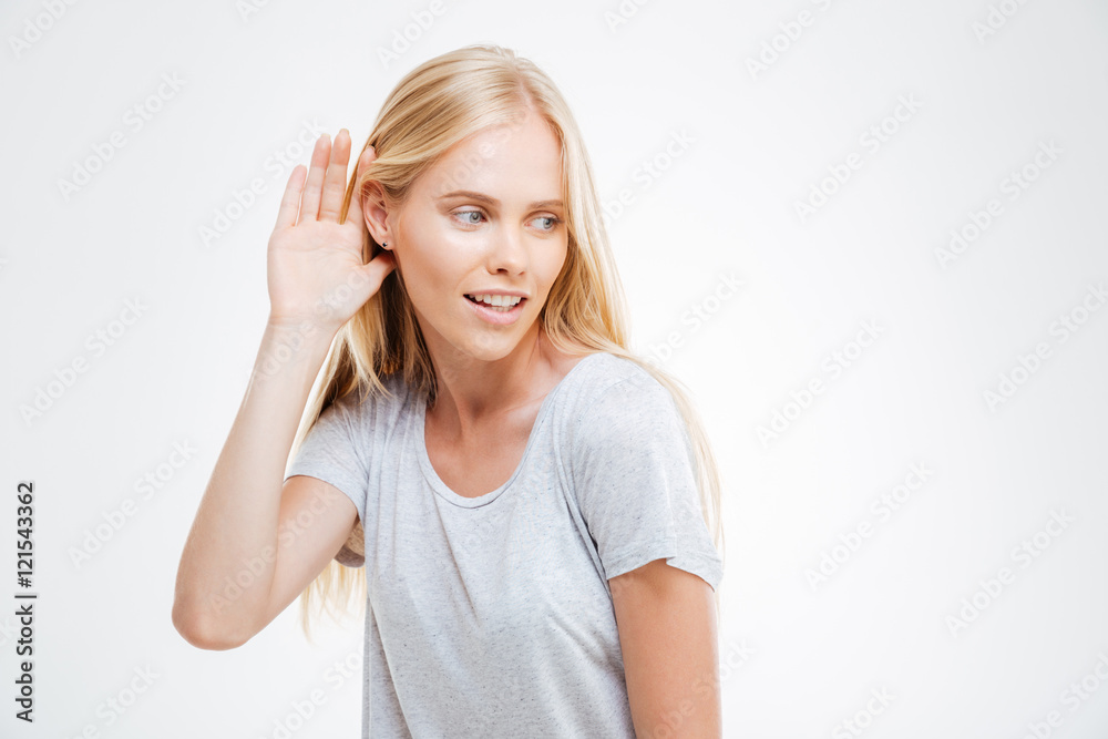 Beautiful woman with hand at the ear to hear better