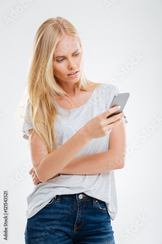 Pensive woman holding smartphone