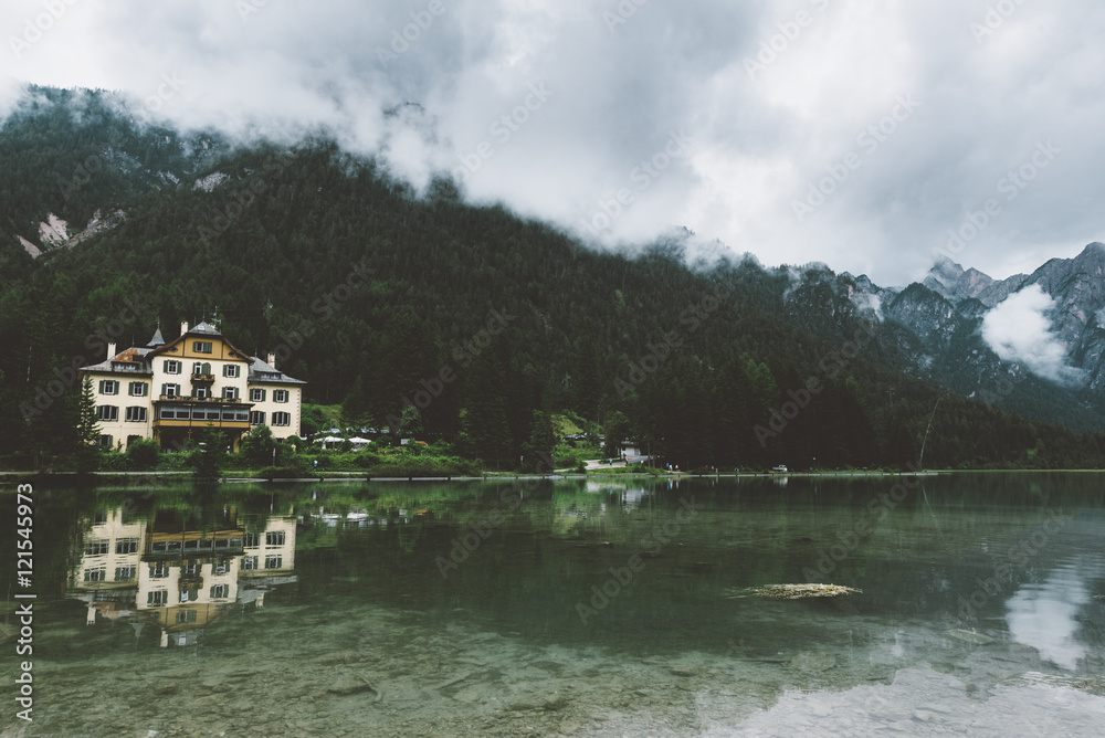 Fototapeta premium Castle by the lake with mountains and fog