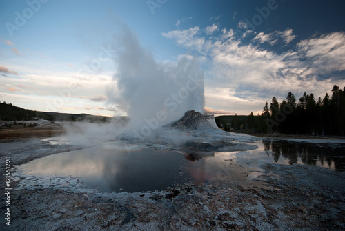 Castle Geyser errupting at sunset in Yellowstone National Park, USA