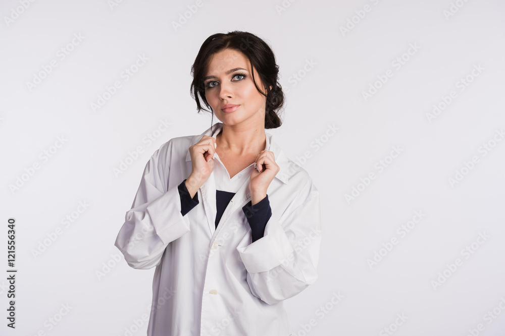 Woman doctor holding up her collar and standing against a white background Woman doctor holding up her collar and standing against a white background