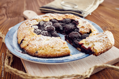 Handmade cherry pie on a blu dish  on a wooden table. Country style.