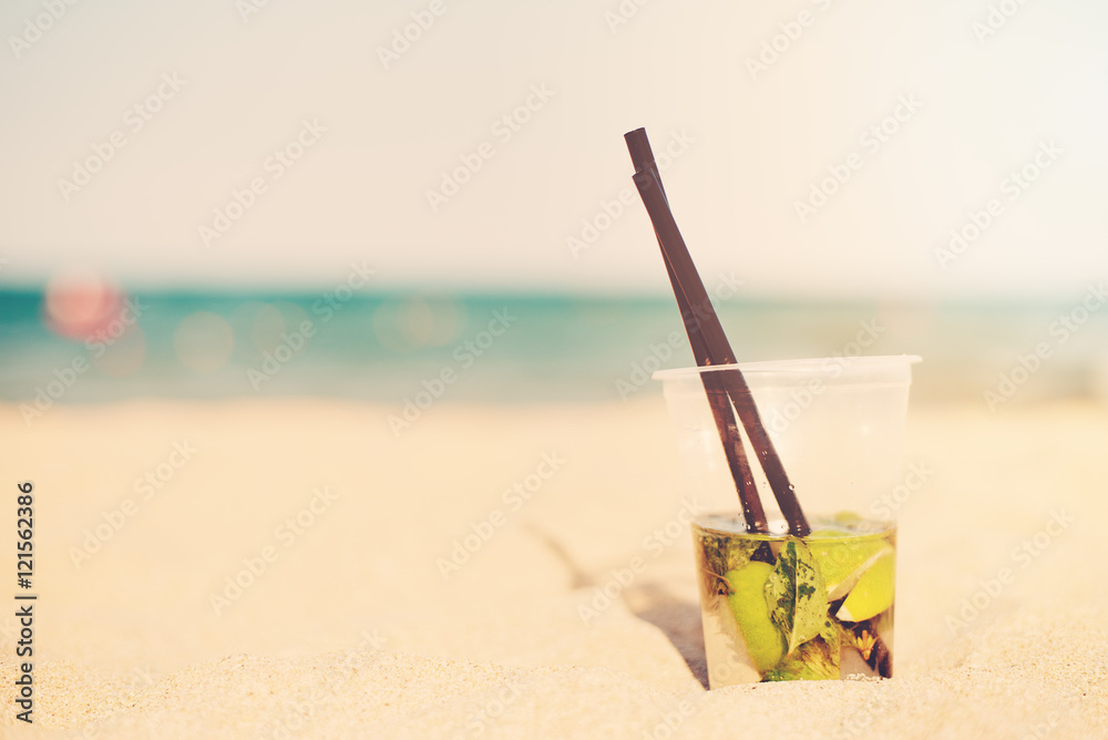 Mojito cocktail on the beach, blurred beach background. Sun, sun haze, glare Mojito cocktail on the beach, blurred beach background. Sun, sun haze, glare
