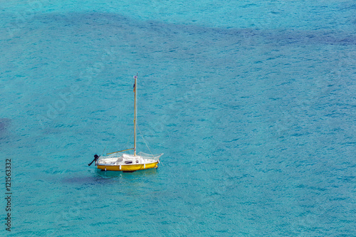 Yellow yacht in the blue sea