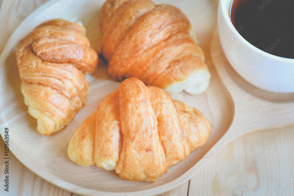 croissants with cup of coffee on wooden background croissants with cup of coffee on wooden background