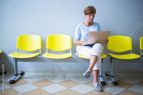 Patient sitting with report in a waiting room