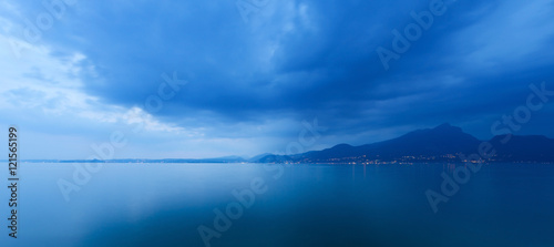 Lago di Garda in the evening (Garda Lake), with the lights of the coast of Lombardy, Italy