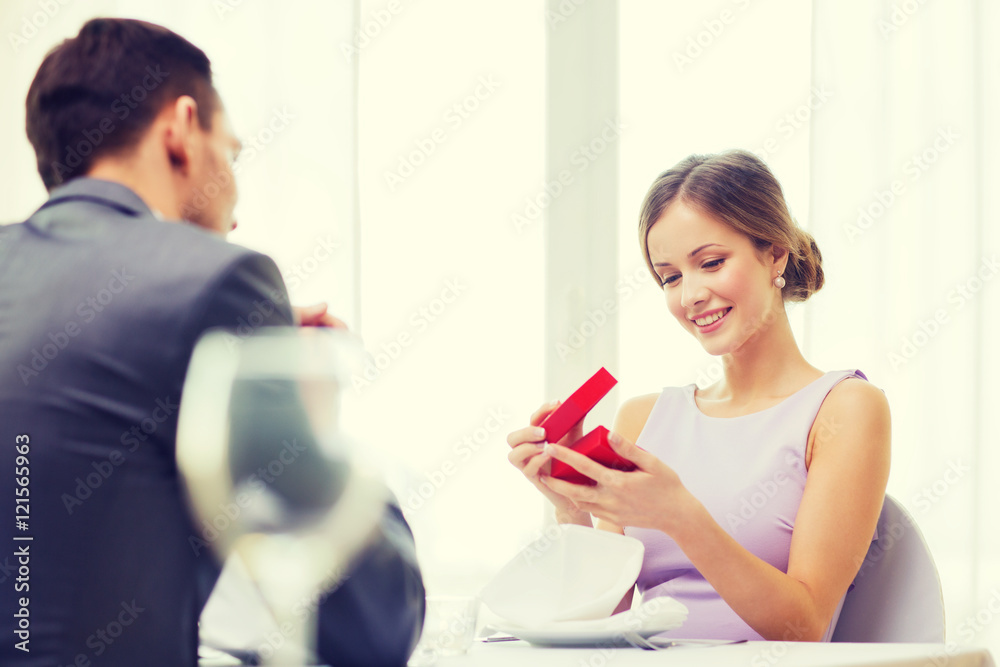 excited young woman looking at boyfriend with box excited young woman looking at boyfriend with box