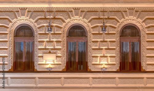 Three windows in a row on night illuminated facade of urban office building front view, St. Petersburg, Russia.