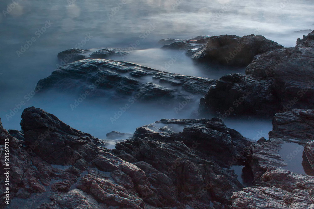 Ocean waves crashing onto the rocks in the sunset Ocean waves crashing onto the rocks in the sunset