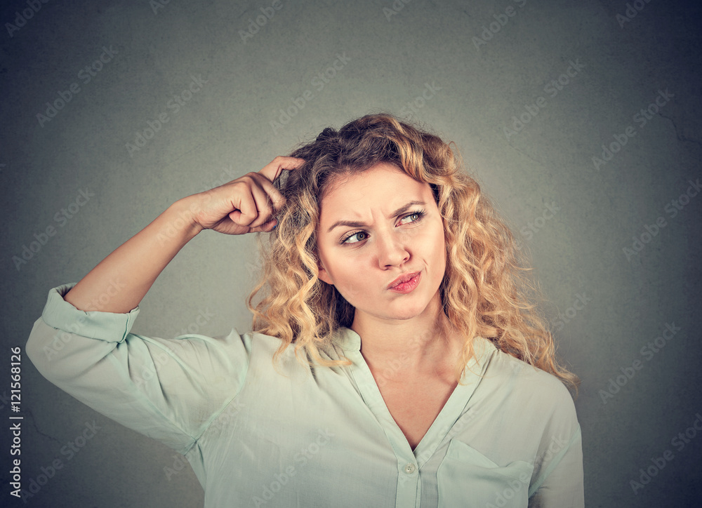 Fototapeta premium Woman scratching head thinking about something looking up