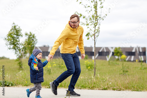 happy father and son with pinwheel toy outdoors