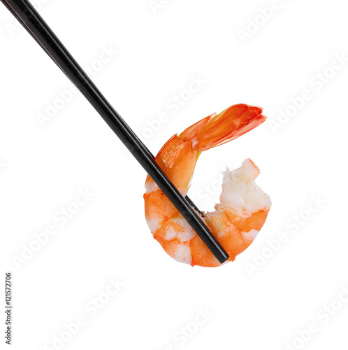 Black chopsticks holding a prawn on white background
