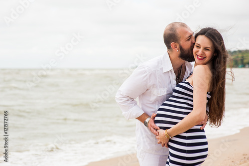 Beautiful young pregnant woman with man on the beach feel peace and tranquility