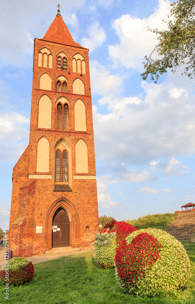 Gothic church of St. Spirit in southern part of Chelmno on Vistula river, built in XIII century. At flower bed visible shape of a red heart from flowers, because Chelmno is called a city of lovers