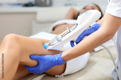 Woman having leg mesotherapy in beauty salon photo