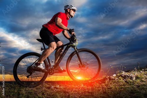 Fototapeta Naklejka Na Ścianę i Meble -  Man in helmet and glasses stay on the bicycle