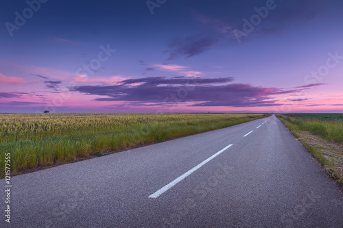 Driving on an open asphalt road at beautiful sunset