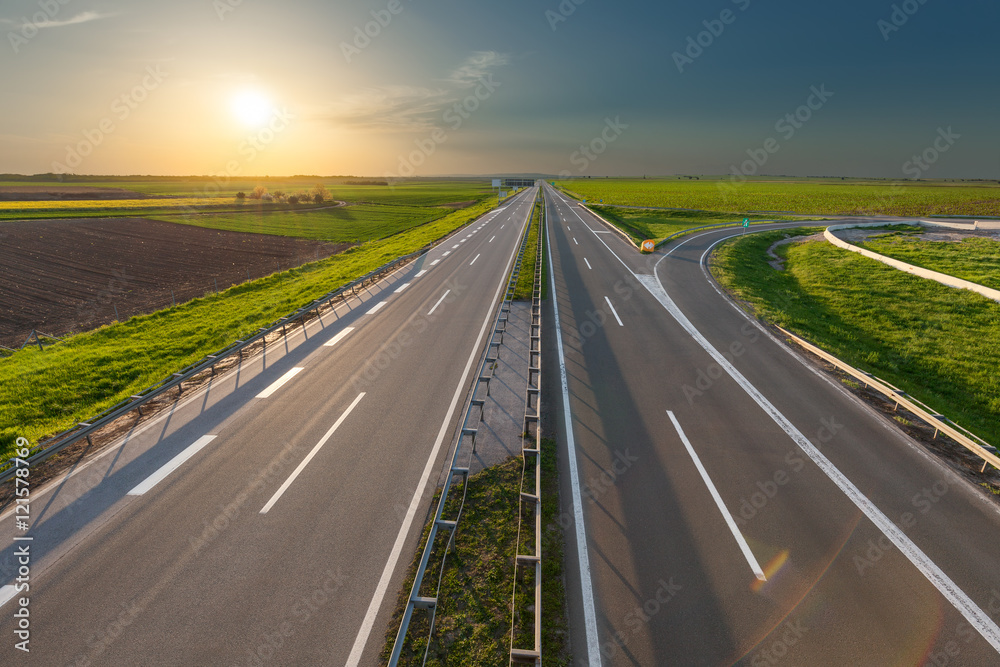 Open freeway through illuminated green idyllic fields Open freeway through illuminated green idyllic fields