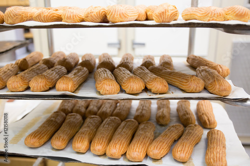 Shelves with baked French baguettes at bakery display