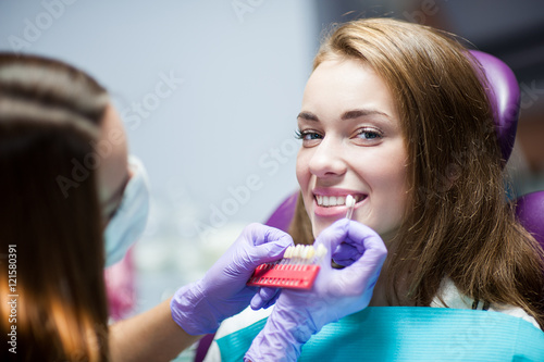 Dentist curing a woman patient in the dental office in a pleasant environment. There are specialized equipment to treat all types of dental diseases in the office.