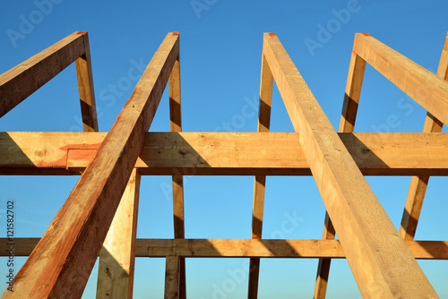 Wooden Roof frame rafters against a blue sky.