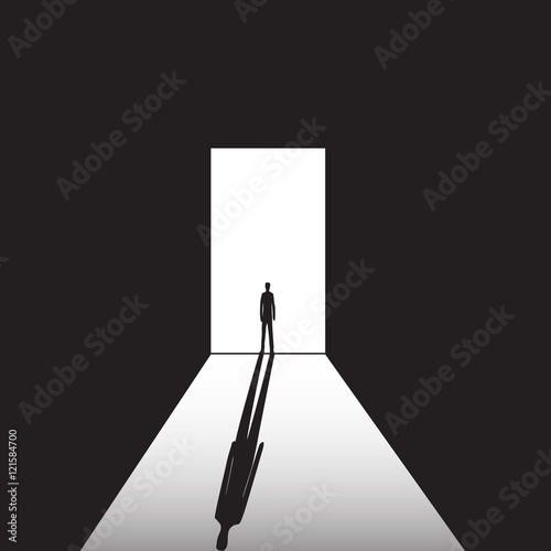 man standing on the bright and the dark background in the doorway with shadow