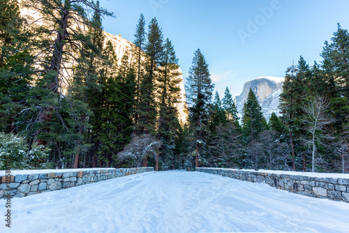 Snowy winter scene on a road with Half Dome in the background in Yosemite National Park