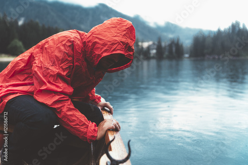 Man with red raincoat is wa...