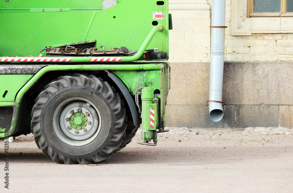 Φωτογραφία wheel and outriggers heavy equipment machine that works near the palace