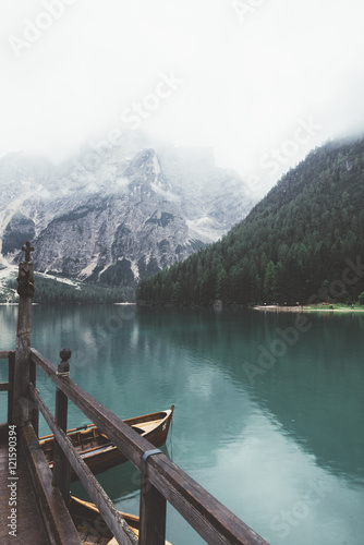 Braies lake with wood building and mountains with trees