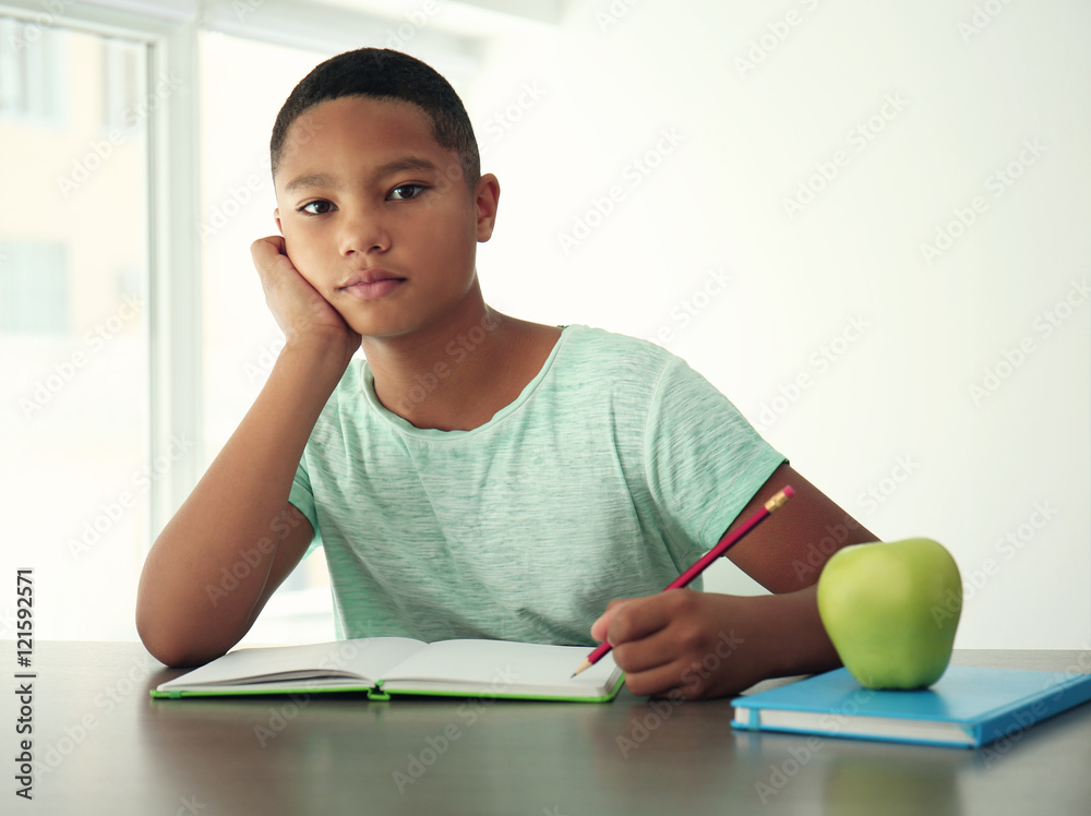 African American boy making homework on light background African American boy making homework on light background