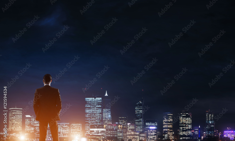 Businessman viewing night glowing city Businessman viewing night glowing city
