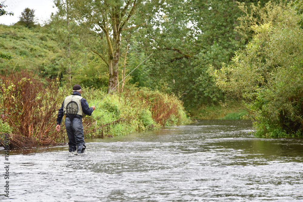 Back view of fly-fisherman fishing in river