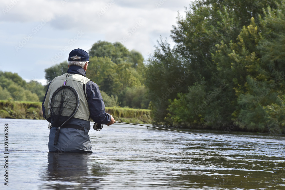 Back view of fly-fisherman fishing in river Back view of fly-fisherman fishing in river