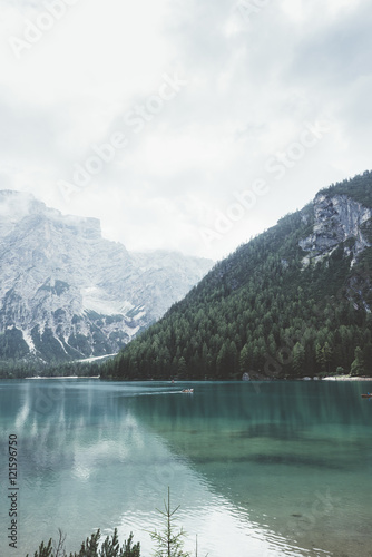 Braies lake with green water and mountains with trees