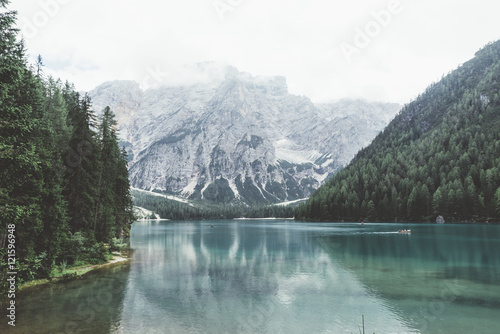 Braies lake with green water and mountains with trees 