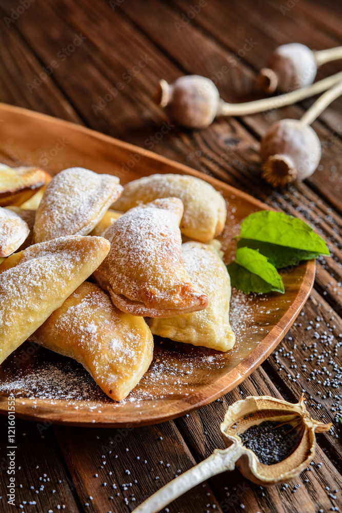 Fototapeta premium Sweet baked dumplings stuffed with poppy seeds and sprinkled with powdered sugar