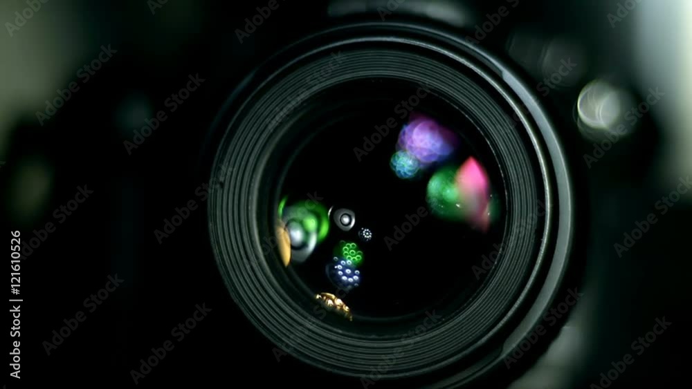 Camera lens with light sources reflecting and illuminating rotation. Shot at high speed 240fps.