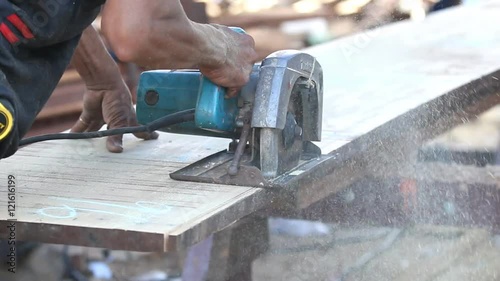 A man using a circular saw to cut the wood
