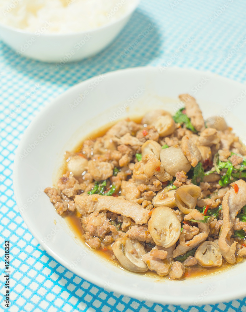 stir fried pork with basil and rice background