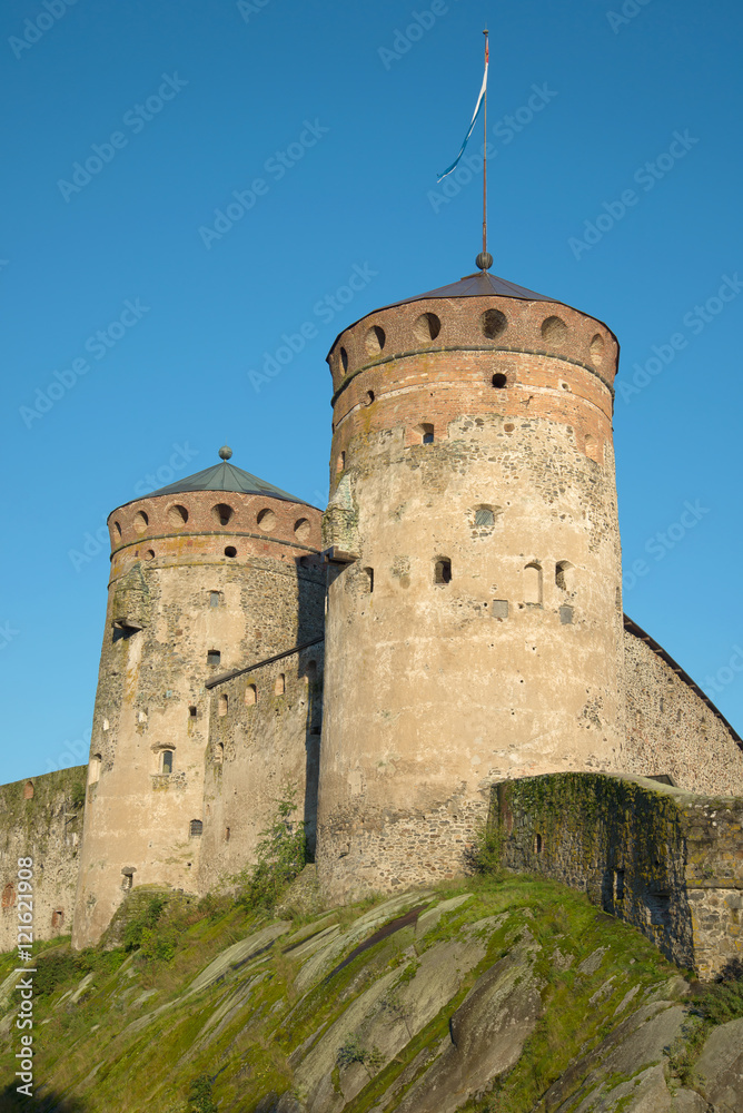 Two medieval towers of the fortress of Olavinlinna closeup on blue sky background. Savonlinna, Finland