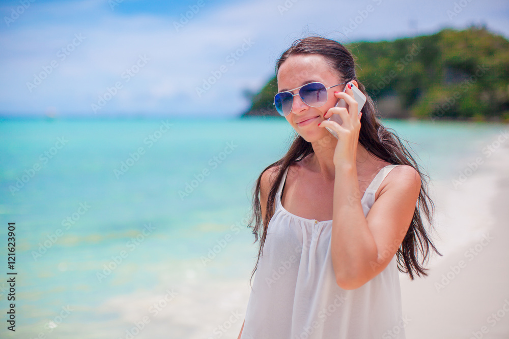 Young beautiful woman at beach talking by her phone