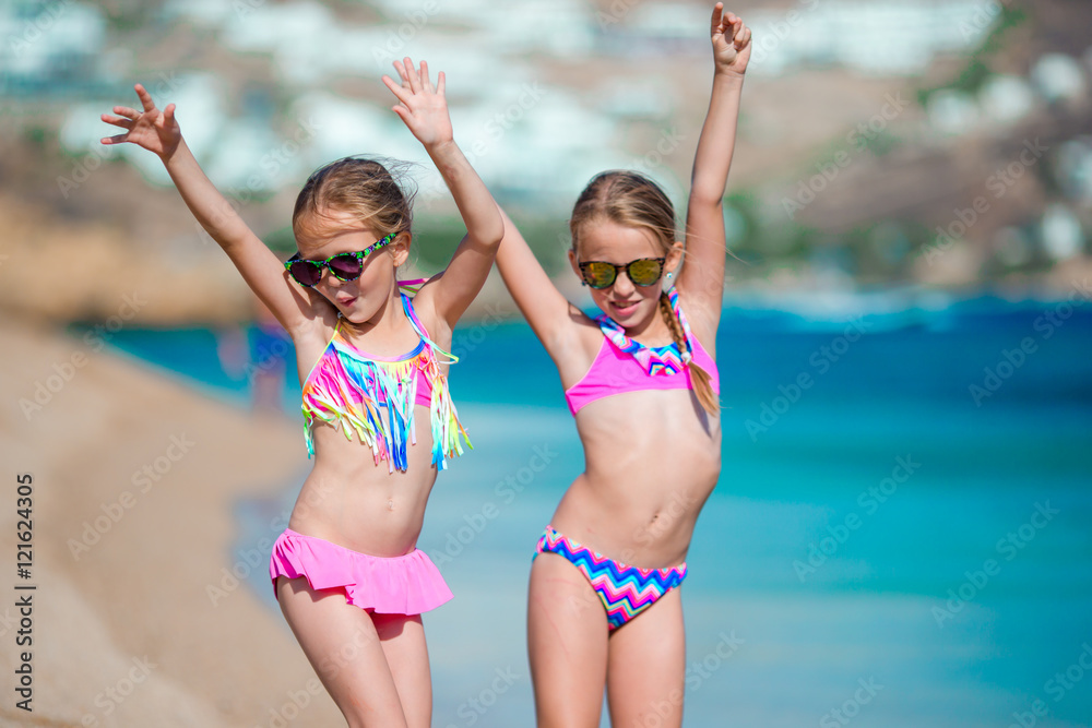 Adorable little girls having fun during beach vacation