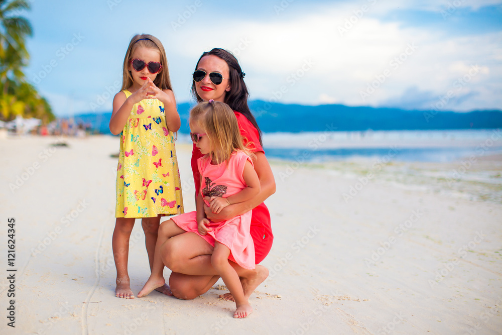 Fototapeta premium Mother and two her kids at exotic beach on sunset